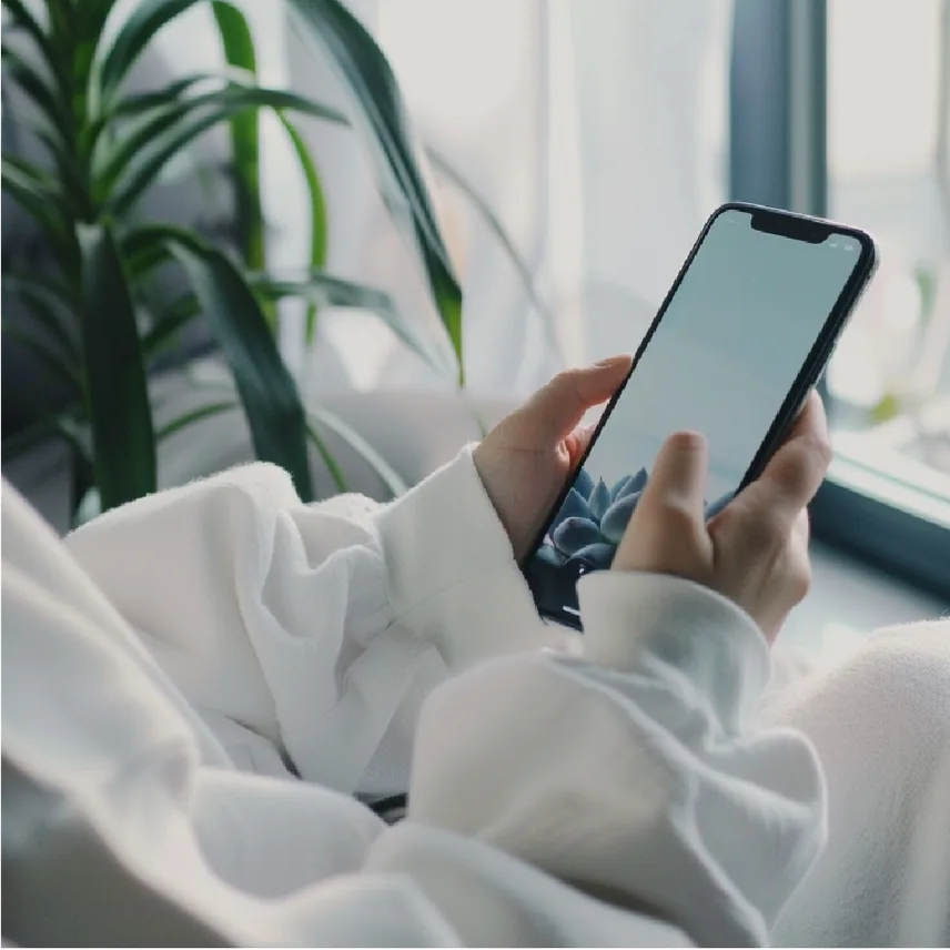 ベッドでスマートフォンを手にしている人